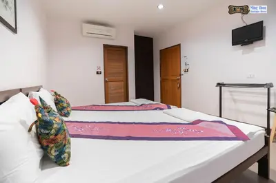 a bedroom with two beds and a flat screen tv at Ming Shou Boutique House in Phuket Town