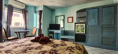 a stuffed animal is laying on a bed in a bedroom at Pension Zum Ross in Karon Beach