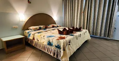 a bedroom with a bed with flowers on it at Pension Zum Ross in Karon Beach