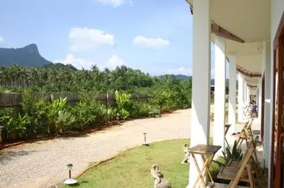 a porch of a house with some animals on the grass at Naga Peak Resort in Ao Nang Beach