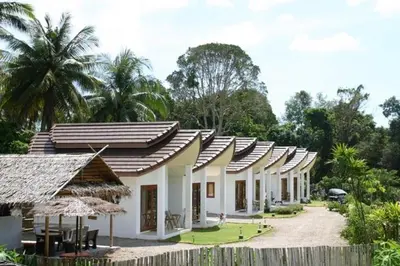 a row of white buildings with trees in the background at Naga Peak Resort in Ao Nang Beach