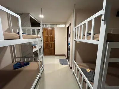 a room with several bunk beds with a hallway at Sabai House in Phi Phi Don