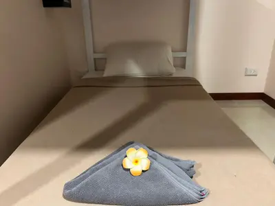 a blue blanket with a yellow flower on a bed at Sabai House in Phi Phi Don
