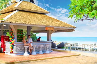 a man and woman sitting in a gazebo at the beach at Beyond Karon in Karon Beach