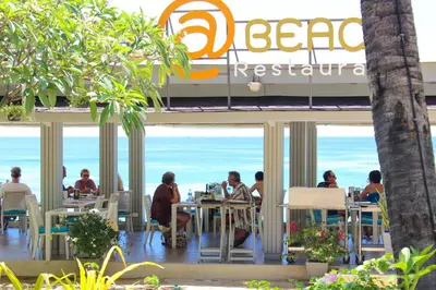 a group of people sitting at tables in front of a restaurant at Beyond Karon in Karon Beach