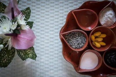 a table with two bowls of cosmetics and a flower at Beyond Karon in Karon Beach