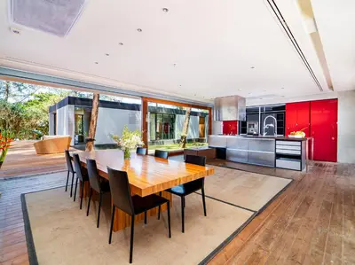 a kitchen and dining room with a wooden table and chairs at Grand Villa Noi in Natai Beach