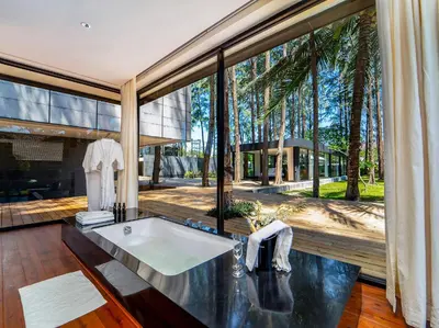 a bathroom with a tub and a large window at Grand Villa Noi in Natai Beach