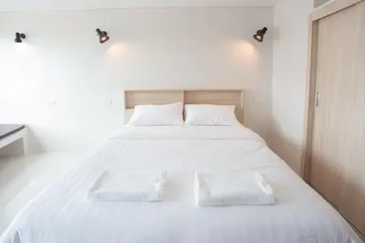 a white bed with two white pillows on it at beHOME Phuket in Nai Yang Beach