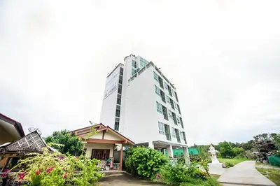 a tall white building with flowers in front of it at beHOME Phuket in Nai Yang Beach