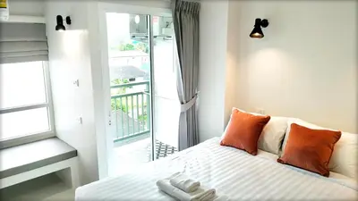 a bedroom with a bed and a balcony at beHOME Phuket in Nai Yang Beach