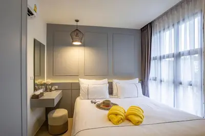 a bedroom with a bed with yellow towels on it at Surin Beach Residence - Official Account in Surin Beach