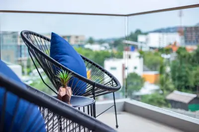 a chair with a blue pillow and a plant on a balcony at Surin Beach Residence - Official Account in Surin Beach