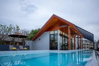 a house with a swimming pool next to a building at Surin Beach Residence - Official Account in Surin Beach