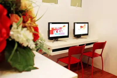 a room with two monitors and two red chairs at The Frutta Boutique in Patong Beach