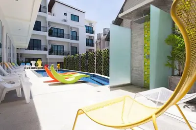 a patio with chairs and a pool in a building at The Frutta Boutique in Patong Beach