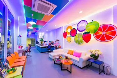 a living room with a white couch and fruits on the wall at The Frutta Boutique in Patong Beach
