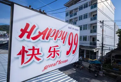a sign for a grocery store on a street at Happy 99 Guest house in Patong Beach