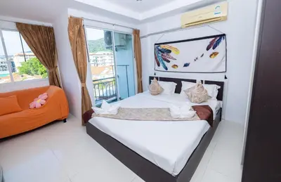 a bedroom with a bed and a orange couch at Happy 99 Guest house in Patong Beach