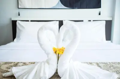 a white swan made out of towels on a bed at Happy 99 Guest house in Patong Beach