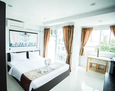 a bedroom with a bed with a swan on it at Happy 99 Guest house in Patong Beach