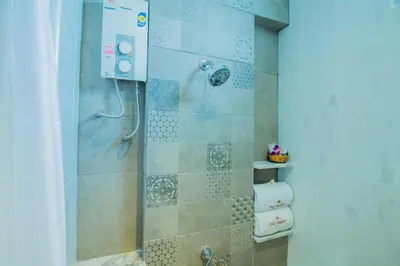 a bathroom with a shower with a toilet at The Rubber Hotel Phuket in Thalang