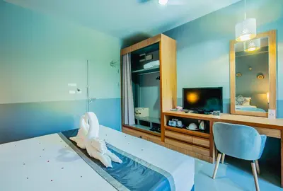 a bedroom with a bed with a mirror and a tv at The Rubber Hotel Phuket in Thalang