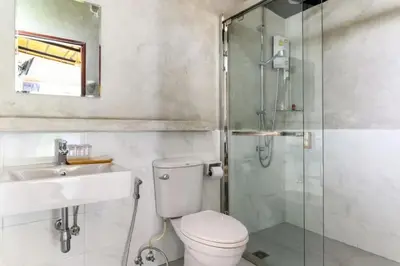 a bathroom with a shower and a toilet and a sink at Loftpical Resort in Phuket Town