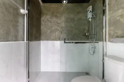 a bathroom with a shower with a toilet and a sink at Loftpical Resort in Phuket Town
