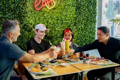 a group of people sitting around a table eating food at UNOTEL Karon Beach in Karon Beach