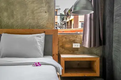 a bedroom with a bed and a lamp and a window at UNOTEL Karon Beach in Karon Beach