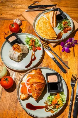 three plates of food on a wooden table at UNOTEL Karon Beach in Karon Beach