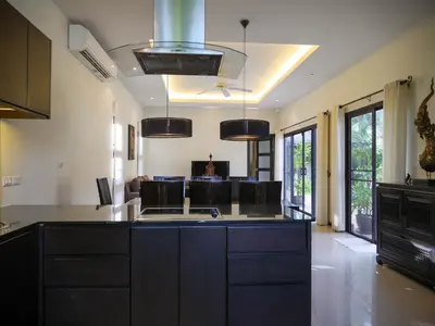a kitchen with black cabinets and a kitchen island at 3bdr Pool villa Naiharn KOK by Capital Pro in Rawai Beach