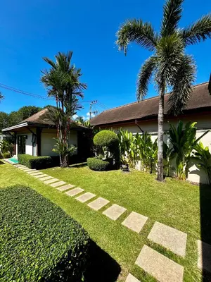 a house with a palm tree and a walkway at 3bdr Pool villa Naiharn KOK by Capital Pro in Rawai Beach
