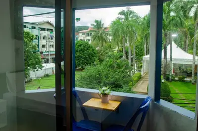 a table and chairs in a window with a view at Allstar Guesthouse in Karon Beach