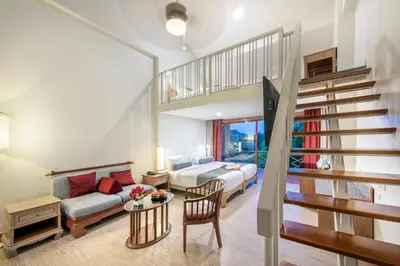 a living room with a staircase leading to a bedroom at Chada Thai Village in Ao Nang Beach