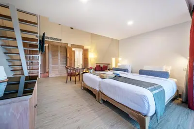 a hotel room with a large bed and a desk at Chada Thai Village in Ao Nang Beach