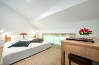 a bedroom with a bed with a desk and a piano at Chada Thai Village in Ao Nang Beach
