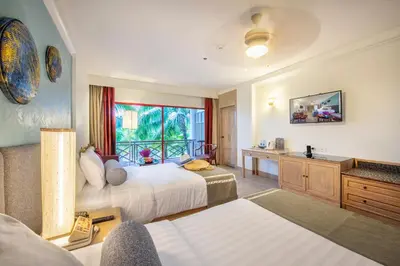 a hotel room with two beds and a window at Chada Thai Village in Ao Nang Beach