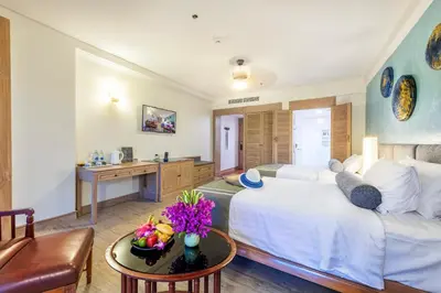 a living room with a large white bed and a table at Chada Thai Village in Ao Nang Beach