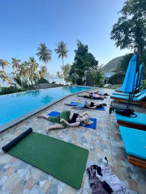 a group of people laying on mats by a swimming pool at Jaiyen Eco Resort in Ko Yao Noi