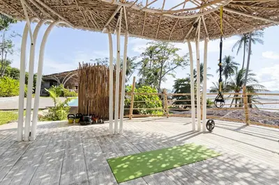 a pavilion with a green yoga mat on a wooden floor at Jaiyen Eco Resort in Ko Yao Noi