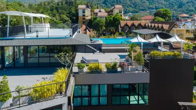 an aerial view of a building with plants on the balconies at KK Karon Kata Boutique Hotel in Kata Beach