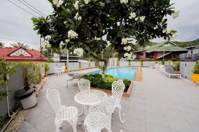 a patio with white tables and chairs and a pool at Aonang Ocean View Studio ( The Sea Condo ) in Ao Nang Beach