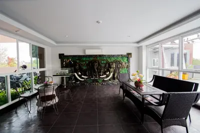 a living room with a table and chairs and windows at Aonang Ocean View Studio ( The Sea Condo ) in Ao Nang Beach