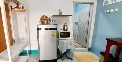 a small kitchen with a microwave on top of a refrigerator at Sala Bua Room in Karon Beach