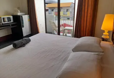 a bed with a pillow on it in a room with a window at Sala Bua Room in Karon Beach
