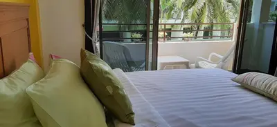a bedroom with a bed with pillows and a balcony at Sala Bua Room in Karon Beach