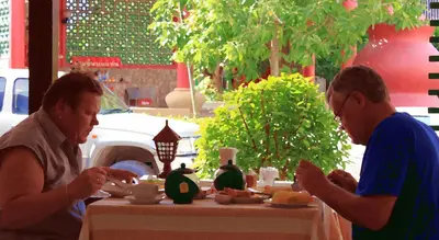 two men sitting at a table eating food at Sala Bua Room in Karon Beach