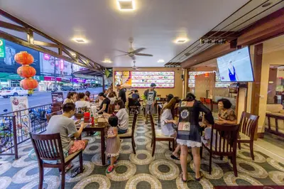 a group of people sitting at tables in a restaurant at Mellow Space Boutique Rooms in Karon Beach